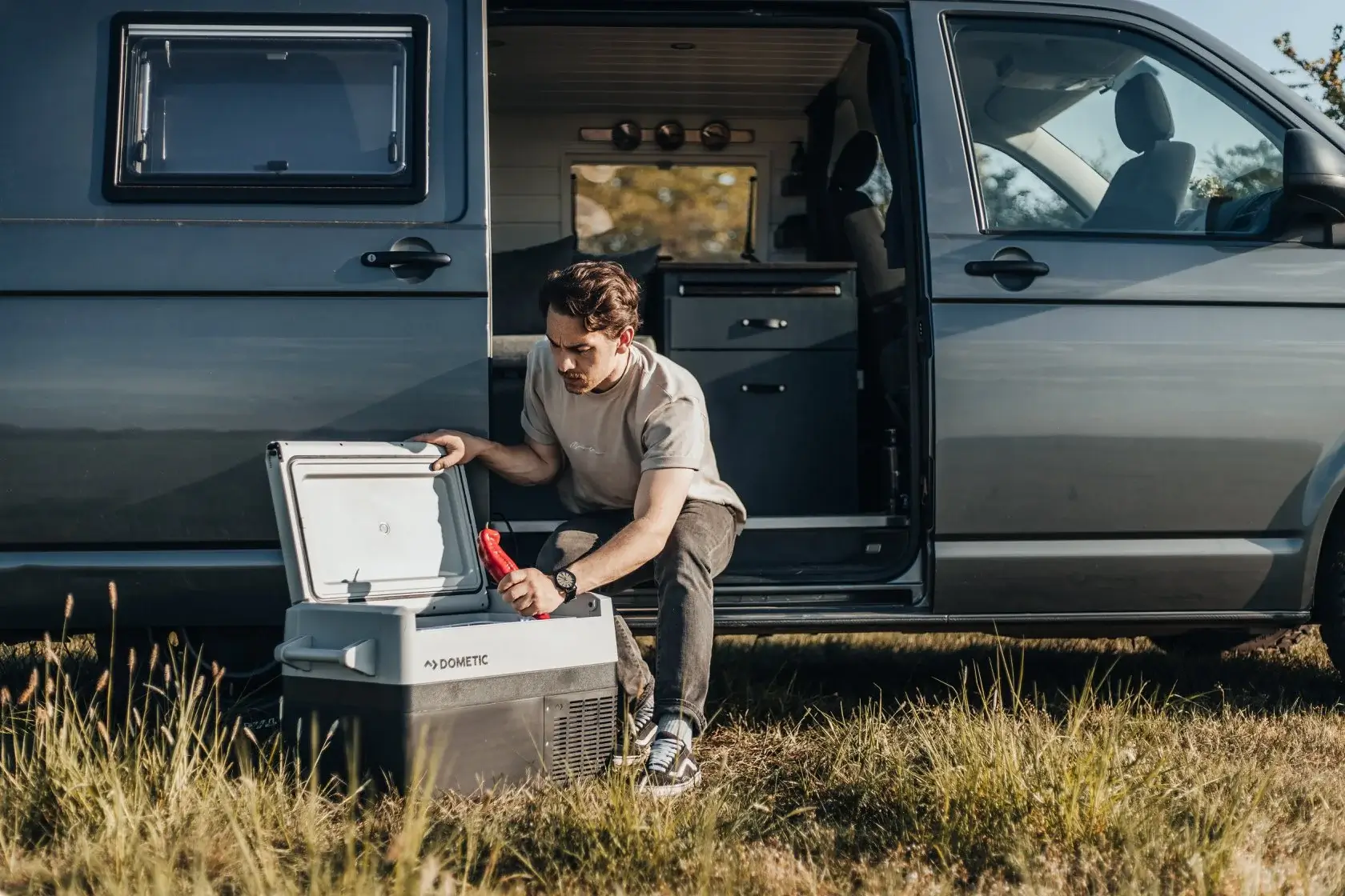 Hombre en una camper con una nevera Dometic